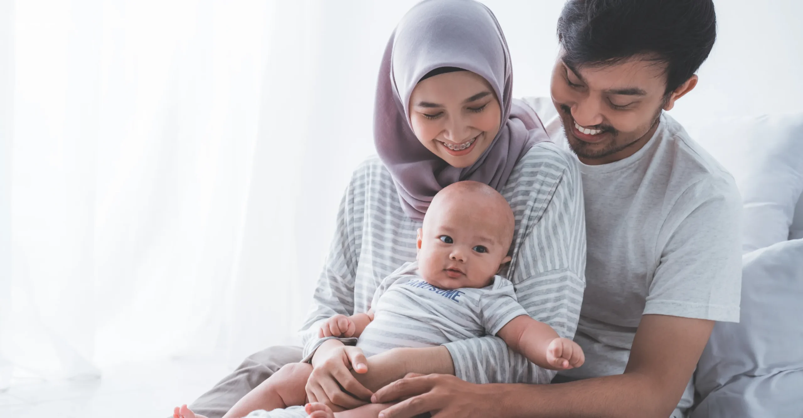 Young parents holding baby together in a bright and comfortable home environment